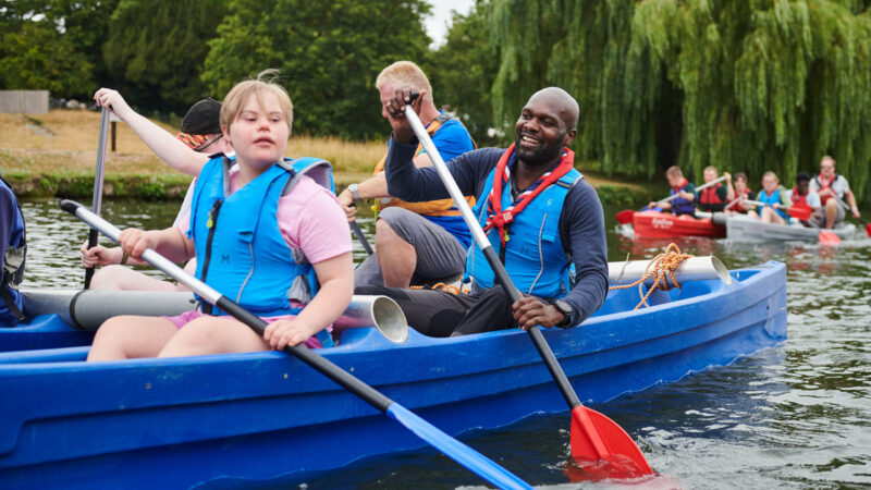 Scout leader and disabled young person in canoe