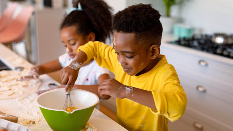 Two young children getting messy cooking together
