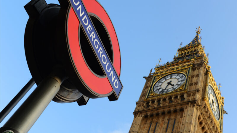 The London Underground sign next to Big Ben in Westminster, London.